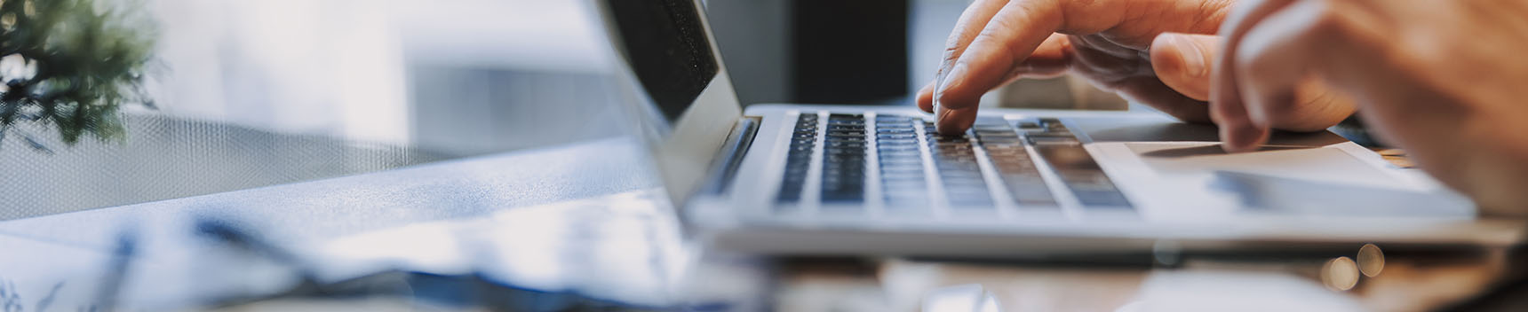 Hands typing on a laptop keyboard