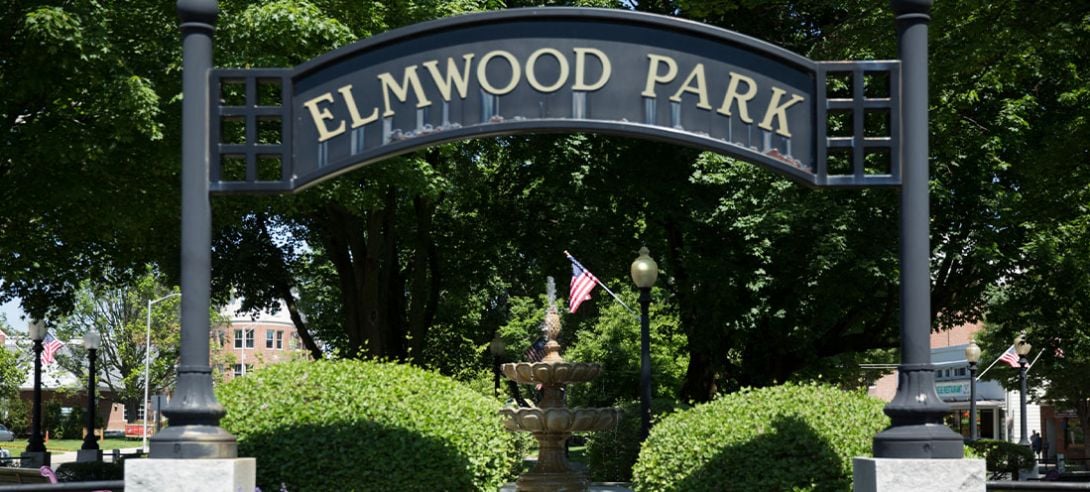 Photo of Elmwood Park sign with a fountain in the background